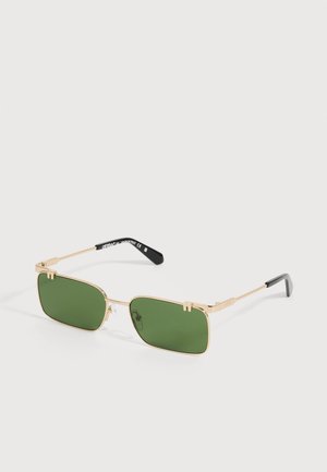 Lunettes de soleil rectangulaires teintées vert avec fines montures métalliques dorées et embouts noirs sur les branches, présentées sur un fond clair uni.