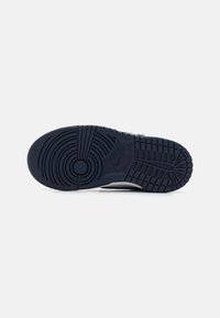 Sötét tengerészkék gumis sneaker talp, körkörös és lineáris mintázattal. Középen kör alakú logó található, valamint textúrázott tapadófelületek.