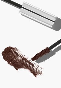 Brun mascararör med en glansig silverkork, bredvid en provswatch av mörkbrun mascara och en applikator med svarta borst.