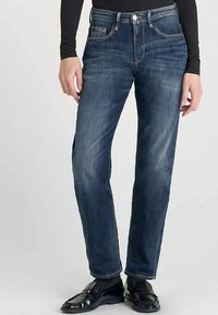 Jean en denim bleu foncé avec une coupe droite, style cinq poches, et une fermeture classique à boutons. Présente un effet de décoloration subtil et des coutures contrastées.