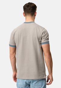 Jasnoszary polo z rypsowym kołnierzykiem w niebieskie i białe paski. Krótkie rękawy, gładka faktura i luźny krój.