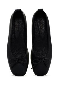 Pumps de ballet de cuero negro con un acabado texturizado, punta redonda y un lazo decorativo en la parte delantera. Forro interior suave.