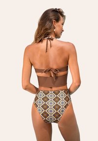 Brązowy biustonosz bikini z wiązaniem na szyi, w połączeniu z wysokim stanem majtek, które mają kolorowy geometryczny wzór oraz gładką teksturę.