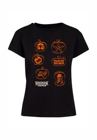 Tricou din bumbac negru cu șase modele de dovleci portocalii cu motive de Halloween și logo-ul "Stranger Things" în partea de jos. Gât rotund, mâneci scurte.