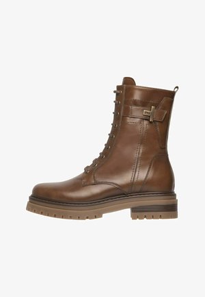 Bruine leren veterschoen met enkelhoogte, voorzien van een stevige rubberen zool en een zijgesp, ontworpen voor casual en robuust gebruik.