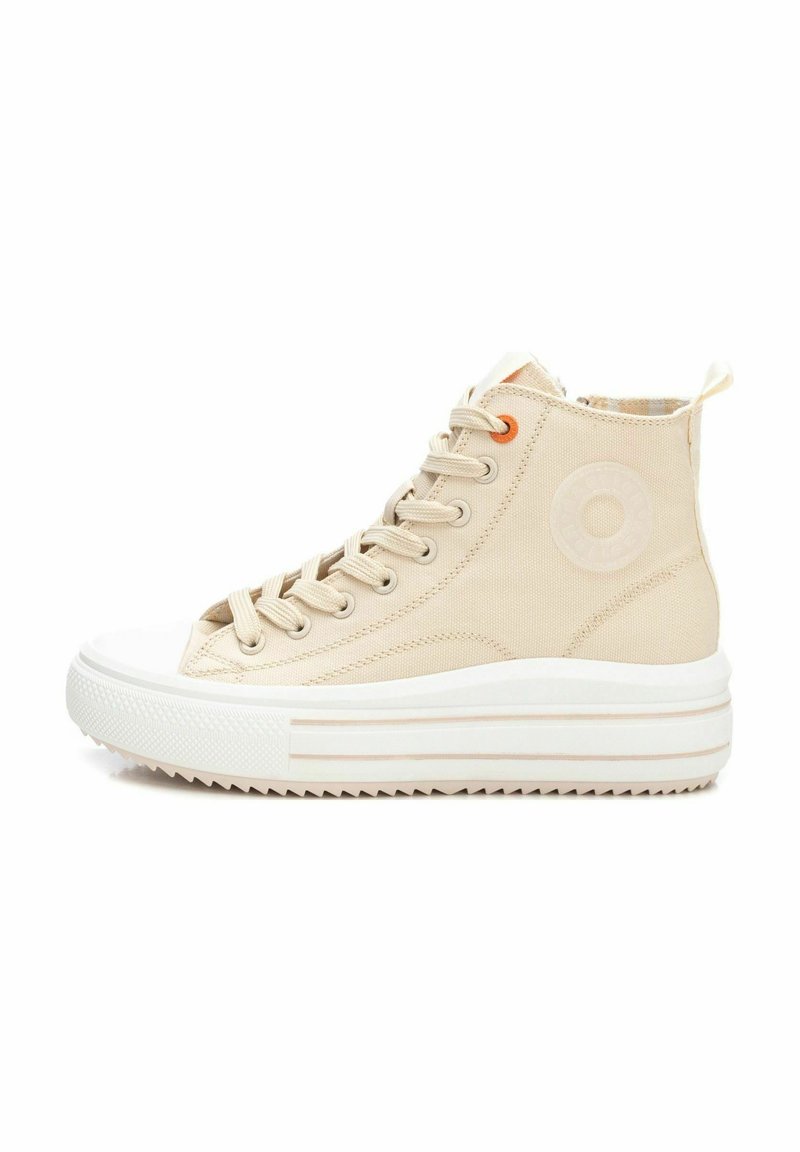 Zapatillas altas de lona beige con punta y suela de goma blanca, que presentan detalles de ojetes naranjas y un acento de logo circular en el lateral.