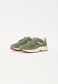 Baskets en mesh vert et en suede avec une semelle rembourrée, dotées d'un intercalaire beige clair et d'une semelle extérieure en caoutchouc marron. Lacets et détails du logo en accent.