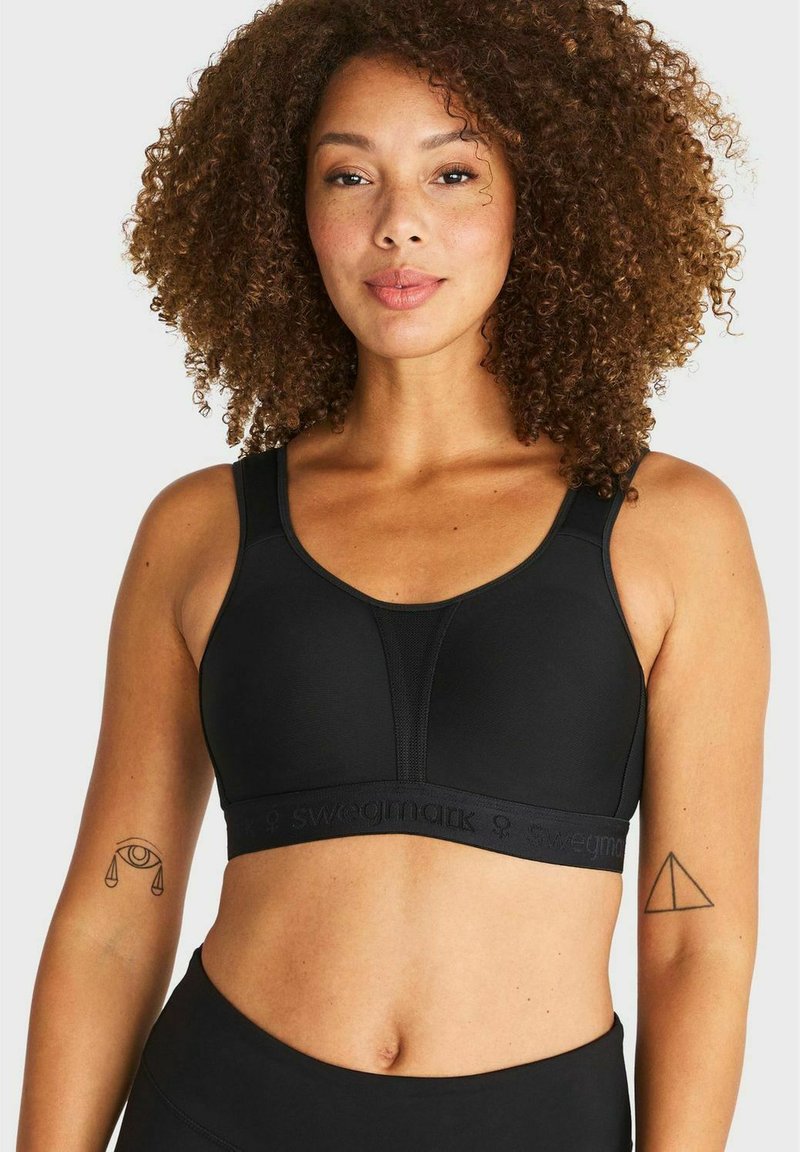 Zwarte sportbeha met brede banden, gladde stof en een gebrande elastische band. Beschikt over een contoured ontwerp en een subtiele textuur.