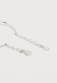 Ασημένια αλυσίδα κολιέ με ρυθμιζόμενους κρίκους, κούμπωμα με μοχλό (lobster clasp) και μικρό μενταγιόν με λογότυπο στα άκρα, τοποθετημένη σε λευκό φόντο.