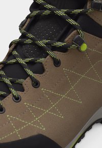 Καφέ δερμάτινο παπούτσι από σουέτ με μαύρη και νέον κίτρινη κορδόνια με σχέδια, ραφές νέον κίτρινες σε γεωμετρικά μοτίβα και στρογγυλό κλείδωμα κορδονιών.