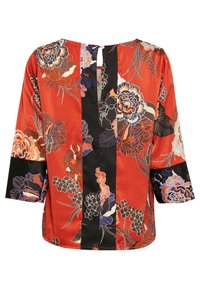 Blusa floreale in tessuto rosso vivace con dettagli neri, maniche a tre quarti e un'apertura a chiave sul retro. La stampa include vari fiori.