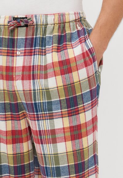 Pantalons de pyjama en mélange de coton à motifs tartan. Présentent des carreaux rouges, bleus, verts et jaunes, une taille élastique, un cordon de serrage ajustable et des poches latérales.