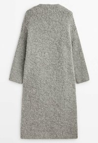 Long cardigan en laine gris tricoté avec manches longues et texture côtelée, posé à plat sur une surface blanche.