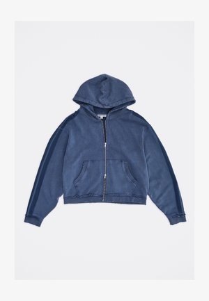 Modrá mikina na zip s kapsami vpředu a dvěma tmavšími modrými pruhy po každém rukávu, rozložená na bílém pozadí.