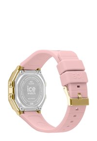 Montre avec un bracelet en silicone rose, dotée d'un boîtier octogonal en or et d'un dos en acier inoxydable. Comprend un fermoir simple et un design de bracelet texturé.