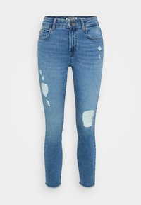 Skinny jeans made of light blue denim, featuring distressed detailing with rips, frayed hems, and classic five-pocket design.