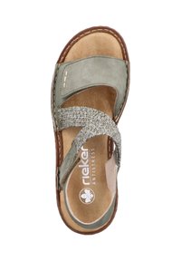 Sandale en daim vert avec une bride en textile tressé, semelle intérieure rembourrée et couture marron, présentant un design facile à enfiler.