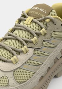 Lightweight, beige and yellow mesh sneakers with a textured upper, contrasting accents, and a cushioned sole, featuring lace-up design.