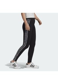 Svartaleggings med blommigt-randiga sidopaneler, som har ett mjukt, stretchigt tyg. Kombineras med vita sneakers med svarta accenter.