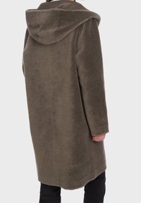 Cappotto verde oliva, morbido, di lunghezza media con un ampio cappuccio, taglio dritto, tessuto strutturato e tasche laterali. Vista posteriore mostrata.