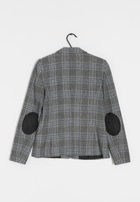 Szary żakiet w kratę z czarnymi zamszowymi łatami na łokciach, pojedynczym rozcięciem z tyłu, kołnierzem i długimi rękawami. Teksturowany materiał z wzorem w kratę.
