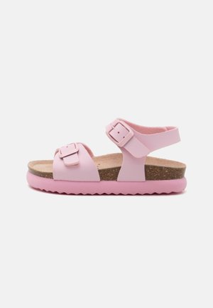 Roze sandaal met twee verstelbare banden, een kurken voetbed en een gestructureerde rubberen zool. Heeft een glad bovenwerk van synthetisch materiaal en details met gespen.