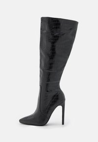 Bottes noires montantes à talons avec un bout pointu, présentant une texture crocodile et une finition brillante. Talon aiguille pour ajouter de la hauteur.