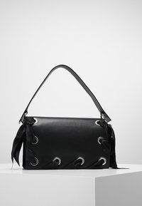 Černá kožená kabelka s hladkým povrchem, s kovovými očky a saténovými akcenty na bocích. Jediný plochý ramenní popruh.