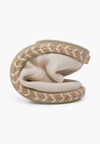 Bottines en tissu de couleur crème à enfiler avec des accents en jute tissé le long des bords. Texture douce et forme arrondie ; design flexible et pliable.