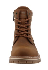 Brązowy skórzany botek do kostki z futerkiem, okrągłym noskiem, metalowymi oczkami i białym szyciem na teksturowanej gumowej podeszwie.