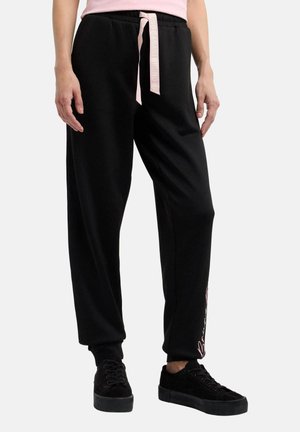 Black jogger pants with a tapered fit, elastic waistband, and a pink drawstring. Features side pockets and white printed text along the leg.