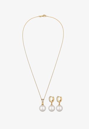 Guldkæde med en fin kæde, der har en stor hvid perlevedhæng, ledsaget af matchende perleøreringe med krystal accenter.