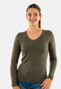 Pull à manches longues ajusté en vert olive avec un décolleté en V, fabriqué à partir d'un matériau doux. La texture côtelée et la coupe slim mettent en valeur la silhouette.