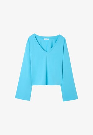 Chemise bleue à manches longues avec un col en V et une coupe ample, présentée sur fond blanc.