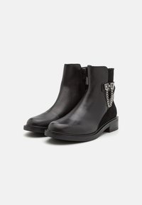 Černé kotníkové boty s hladkou kůží a semišovými detaily, kulatou špičkou, bočním zipem a dekorativními řetízkovými ozdobami.