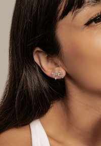 Silver earrings with multiple star-shaped accents, embellished with small clear gemstones, showcasing a delicate and modern design.