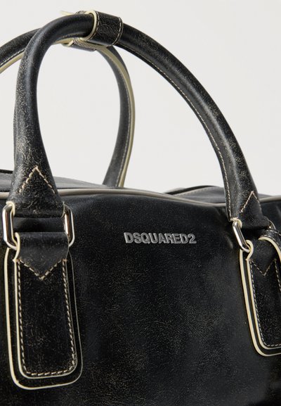 Sac à main en cuir noir Dsquared2 avec doubles poignées, coutures beige et boucles métalliques argentées sur fond uni.