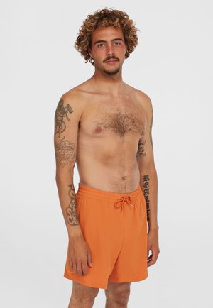 Oranssit uimashortsit, jotka on valmistettu kevyestä kankaasta. Ominaisuuksiin kuuluvat joustava vyötärö, jossa on naru, polvitason malli ja sileä pinta.