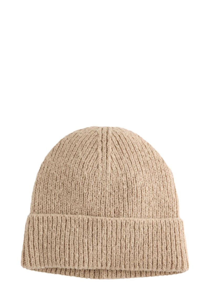 Bonnet en tricot beige, présentant une texture côtelée et un revers plié. Fabriqué en matière douce, avec un dessus arrondi et des lignes verticales.