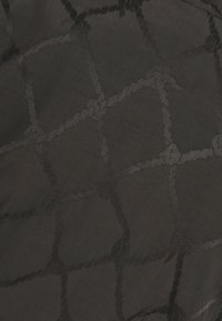 Textil negro con un patrón en relieve de líneas entrelazadas que crean un diseño de cuadrícula, con una textura suave y un brillo sutil.