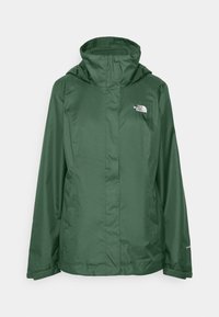 Giacca impermeabile verde con colletto alto, zip completa e cappuccio regolabile. Presenta il logo North Face sul petto e tasche laterali.