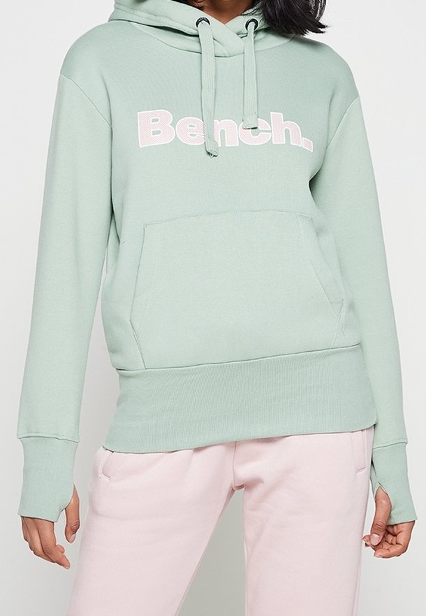 Hoodie verde menta con tasca anteriore, vestibilità ampia e cappuccio con cordino. Presenta il testo bianco "Bench." sul petto. Tessuto morbido, polsini a coste.