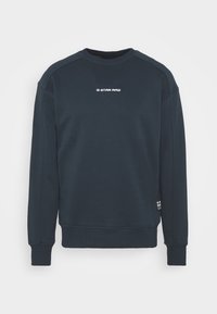 Sweatshirt bleu marine foncé en mélange de coton, avec un col rond, des poignets côtelés et le logo "G-STAR RAW" en blanc sur la poitrine.