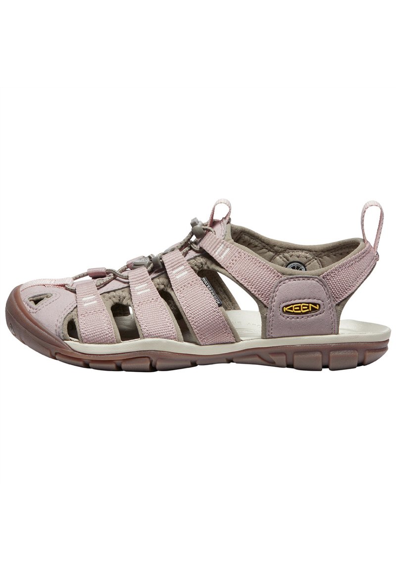 Pink and beige sporty sandal with multiple adjustable straps, textured cushioning, and a rubber sole featuring a grooved pattern.