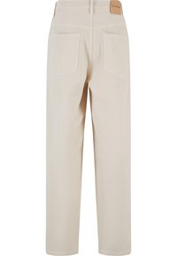 Beige wide-leg pants with a smooth texture, featuring two back pockets and a leather patch at the waistband.