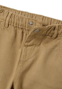 Pantalones de algodón tejido color beige con cintura elástica, cierre de botón metálico y bolsillo lateral. Tejido texturizado con un patrón de canalé vertical.