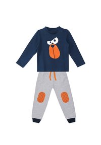 Marineblaue Langarmbluse mit Grafik eines weißen und orangefarbenen Hundegesichts; graue Hose mit orangen karierten Knie-Patches und marineblauen Bündchen.