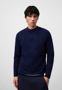 Maglione a maglia blu navy con strisce verticali testurizzate, colletto rotondo e maniche lunghe, realizzato in un materiale morbido e caldo.