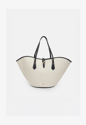 Beige Leinwandtasche mit schwarzem Lederbesatz, doppelten Griffen und einem kleinen goldenen Verschluss vor weißem Hintergrund.