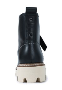 Botín negro de cuero hasta el tobillo con una suela plana beige con prominentes tacos, tira trasera para facilitar el calzado y costuras blancas contrastantes a lo largo del borde.